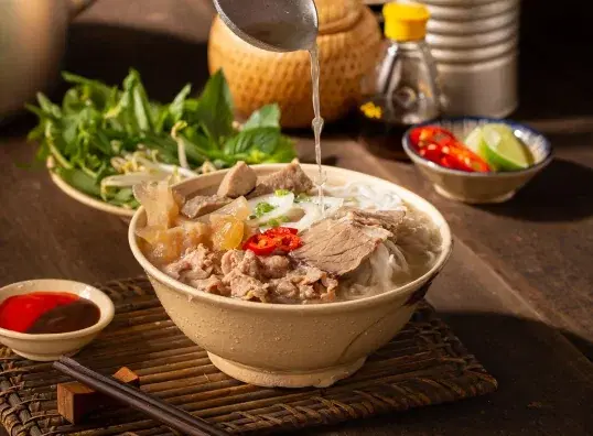 Tô phở bò với rau thơm và nước chấm
